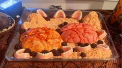 Halloweenský dezert ve tvaru mozku, zubů a pavouků na plechu s pískovou krustou.