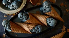 Zmrzlinové kornouty s temně šedými lebkami, originální halloweenský dezert.