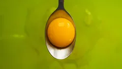 Detail žloutku na šedé lžíci, selektivní zaměření