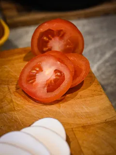 Nakrájená rajčata na prkénku s nožem