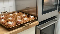 Čerstvé skořicové šneky na plechu připravené k pečení v troubě v kuchyni